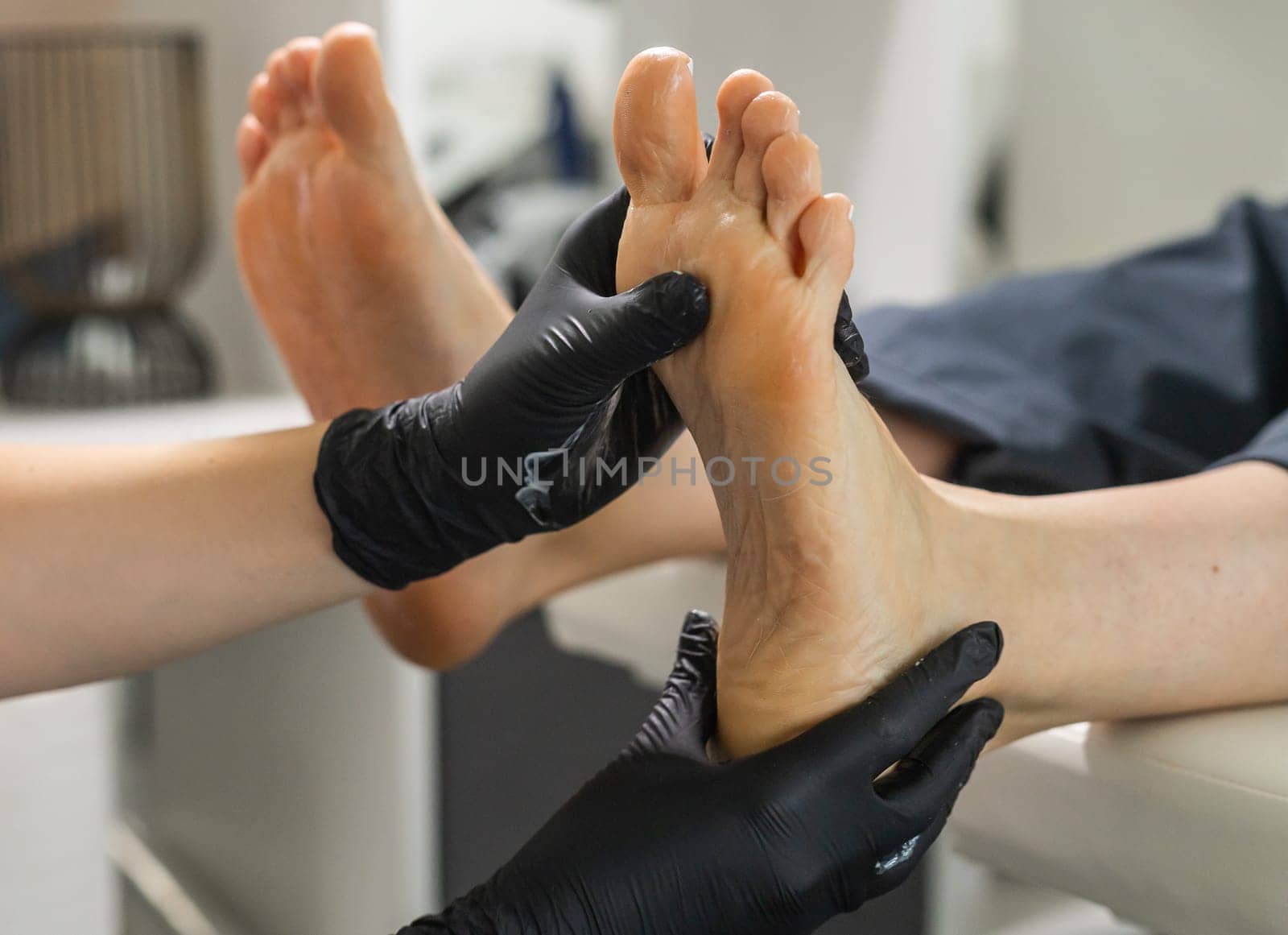 Peeling feet pedicure procedure in a beauty salon. Sugar scrub and relax beauty procedure.