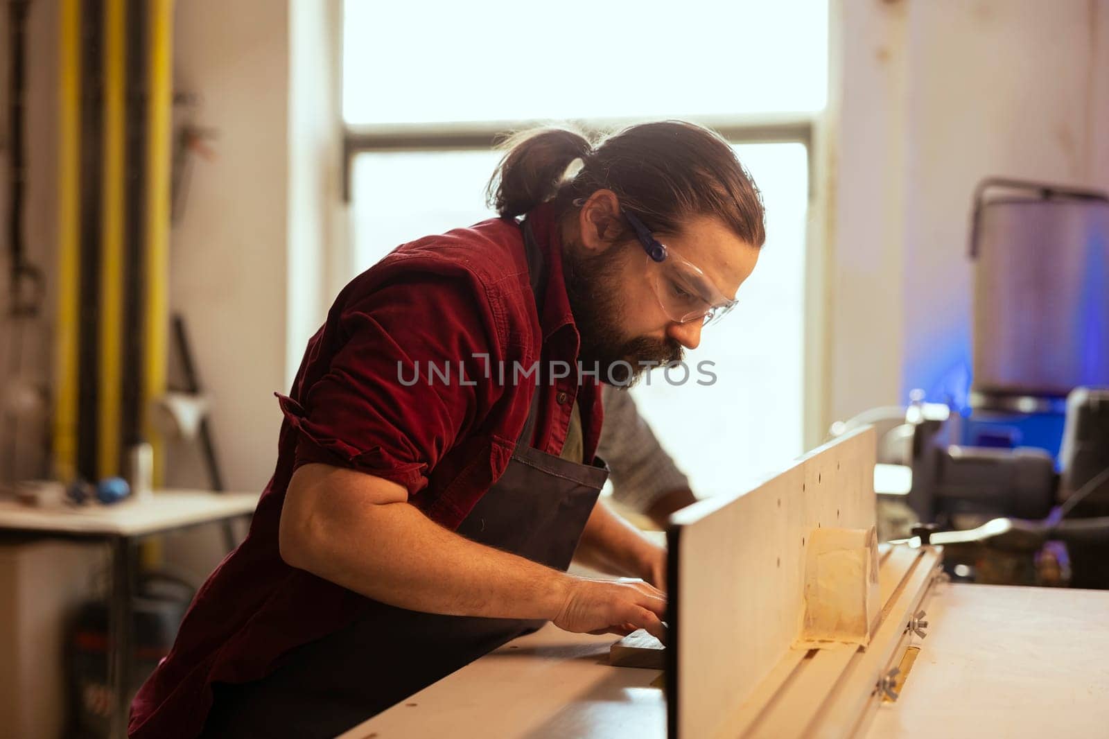 Man wears safety gear while working with spindle moulder to prevent accidents by DCStudio