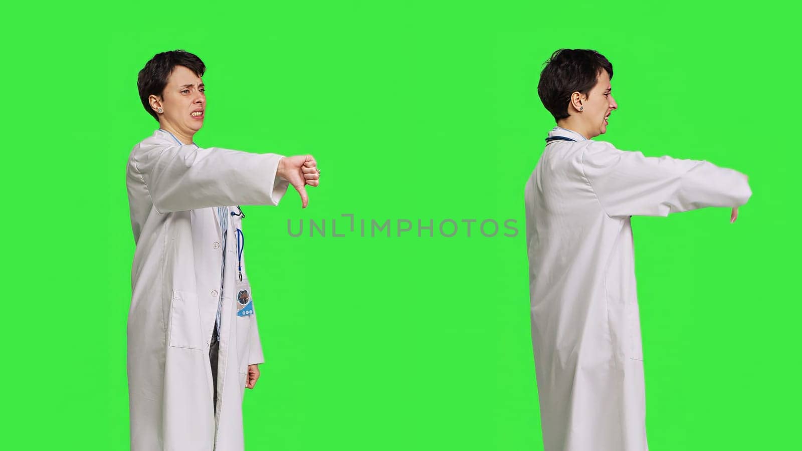 Displeased physician showing thumbs down symbol against greenscreen backdrop, expresses negativity and rejection. Doctor feeling dissatisfied and disagreeing with an idea, dislike sign. Camera B.