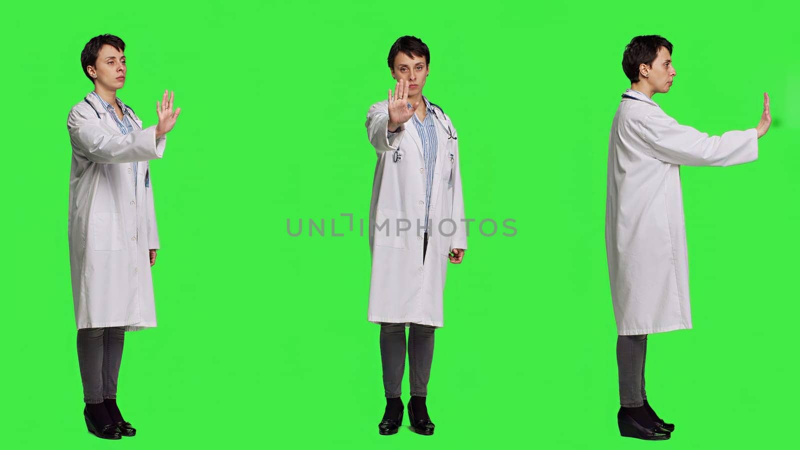 Woman physician raising palm and doing stop sign in studio by DCStudio