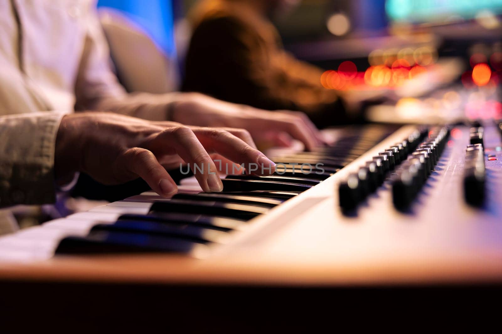 Singer songwriter creating new tracks on midi controller in studio by DCStudio