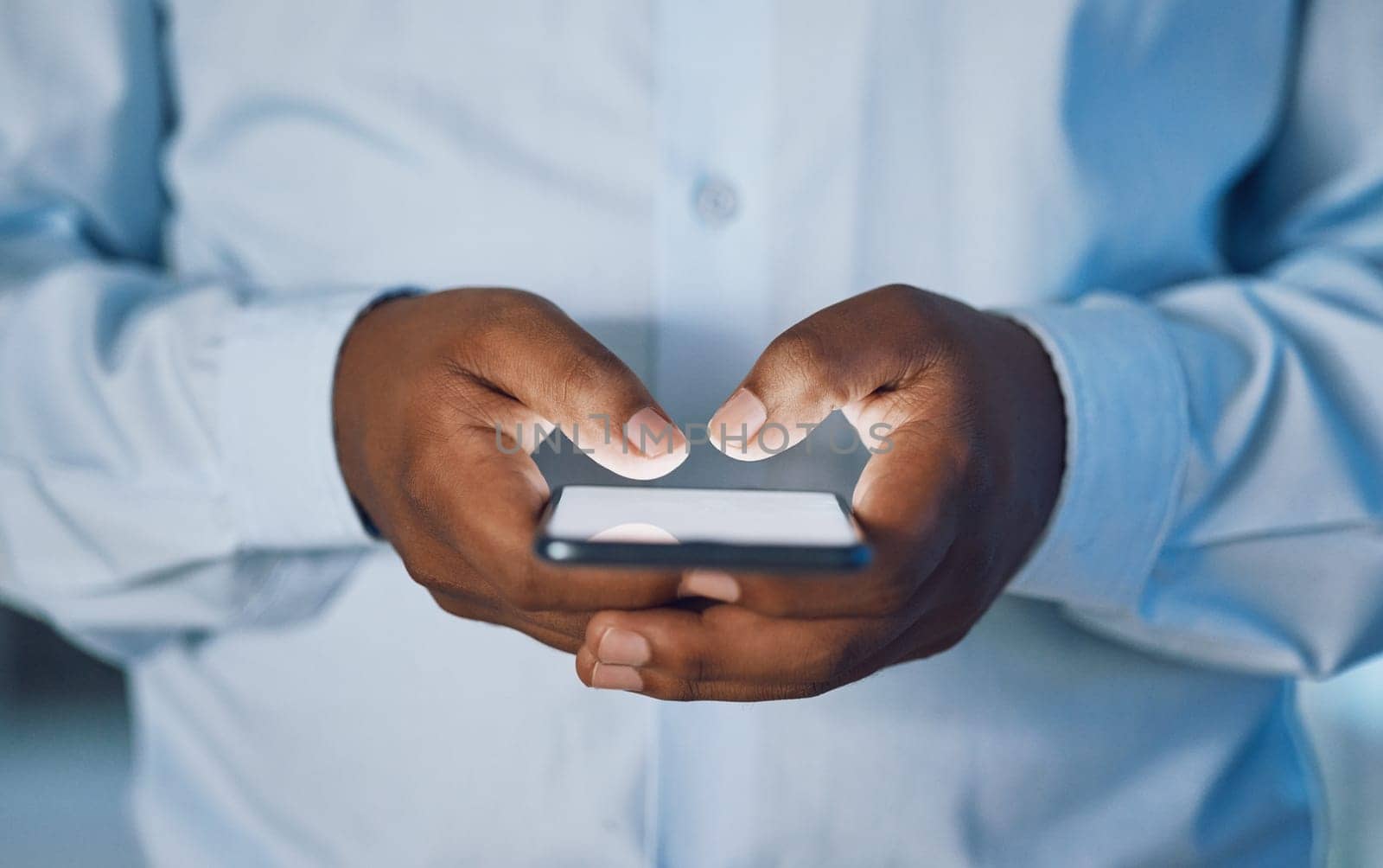 Man, hands and typing with phone for news, social media or online browsing at office. Closeup of African, male person or employee on mobile smartphone for chatting, texting or scrolling on app by YuriArcurs