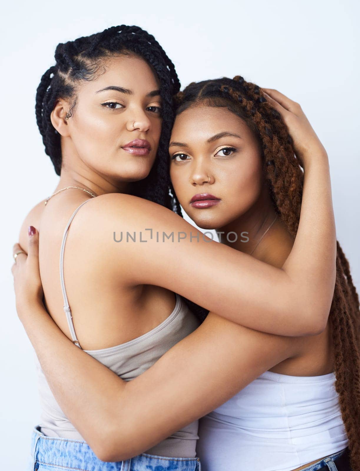 Sisters, portrait and style in studio, hug and aesthetic bonding on white background. Women, friends and embrace for relationship on backdrop, casual outfit and fashion pride for trend or support by YuriArcurs