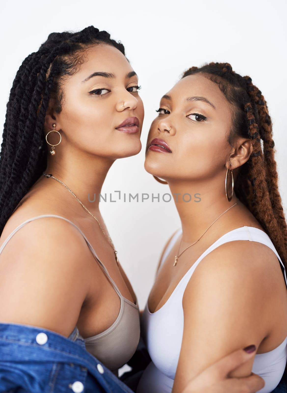 Family, fashion and portrait of black woman with sister in studio on white background for style. Attitude, confident or serious with teen model and sibling in casual outfit for trendy style together.