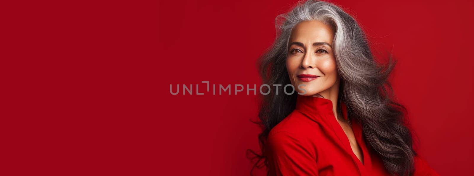 Elegant, elderly, chic Latino, Spain woman with gray long hair and perfect skin, on a red background, banner. Advertising of cosmetic products, spa treatments, shampoos and hair care products dentistry and medicine, perfumes and cosmetology for women