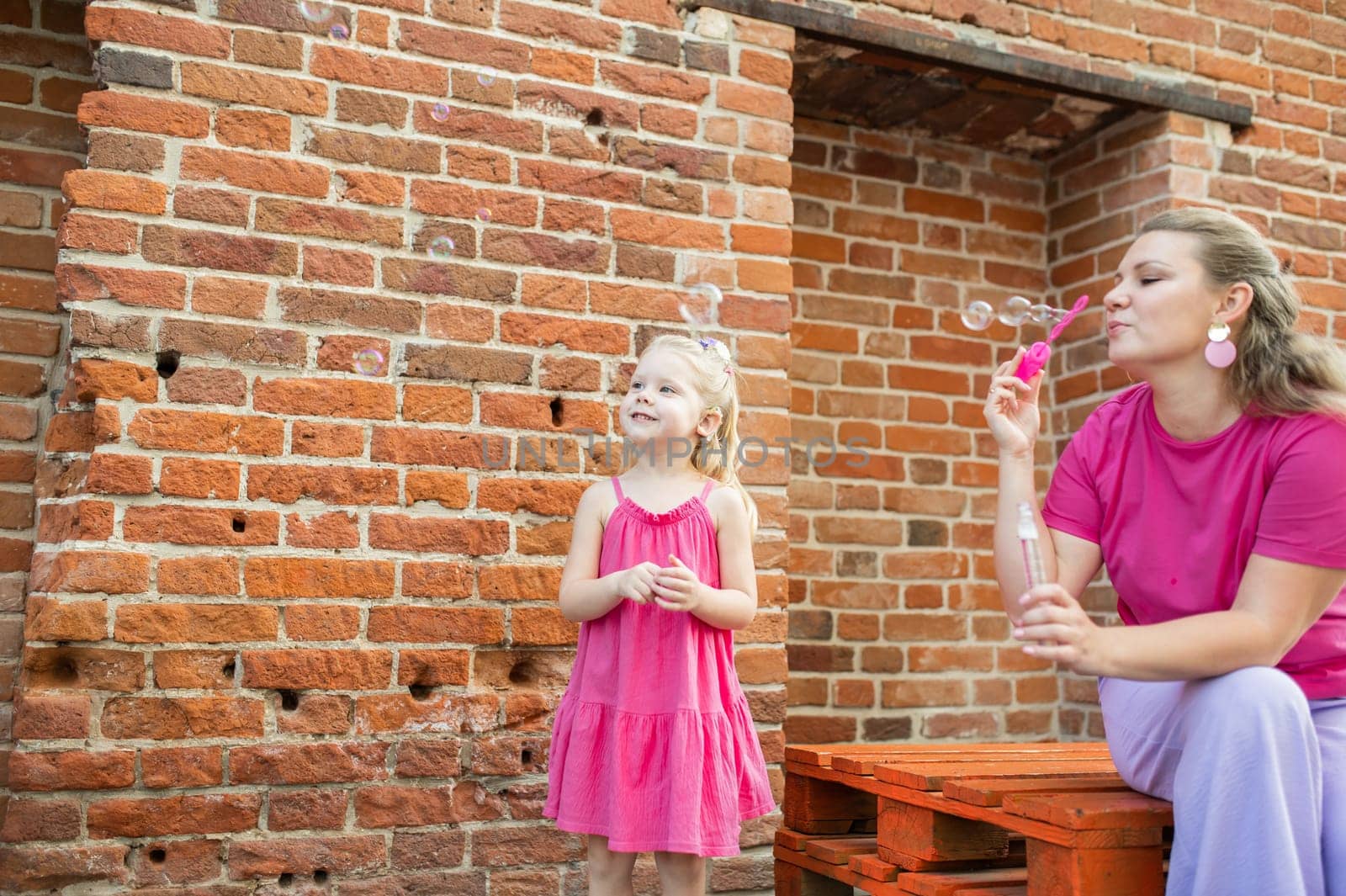 Child girl with cochlear implant with her mother spend time outdoor. Hear impairment and deaf community concept. Deaf and health concept. Diversity and inclusion. Copy space.