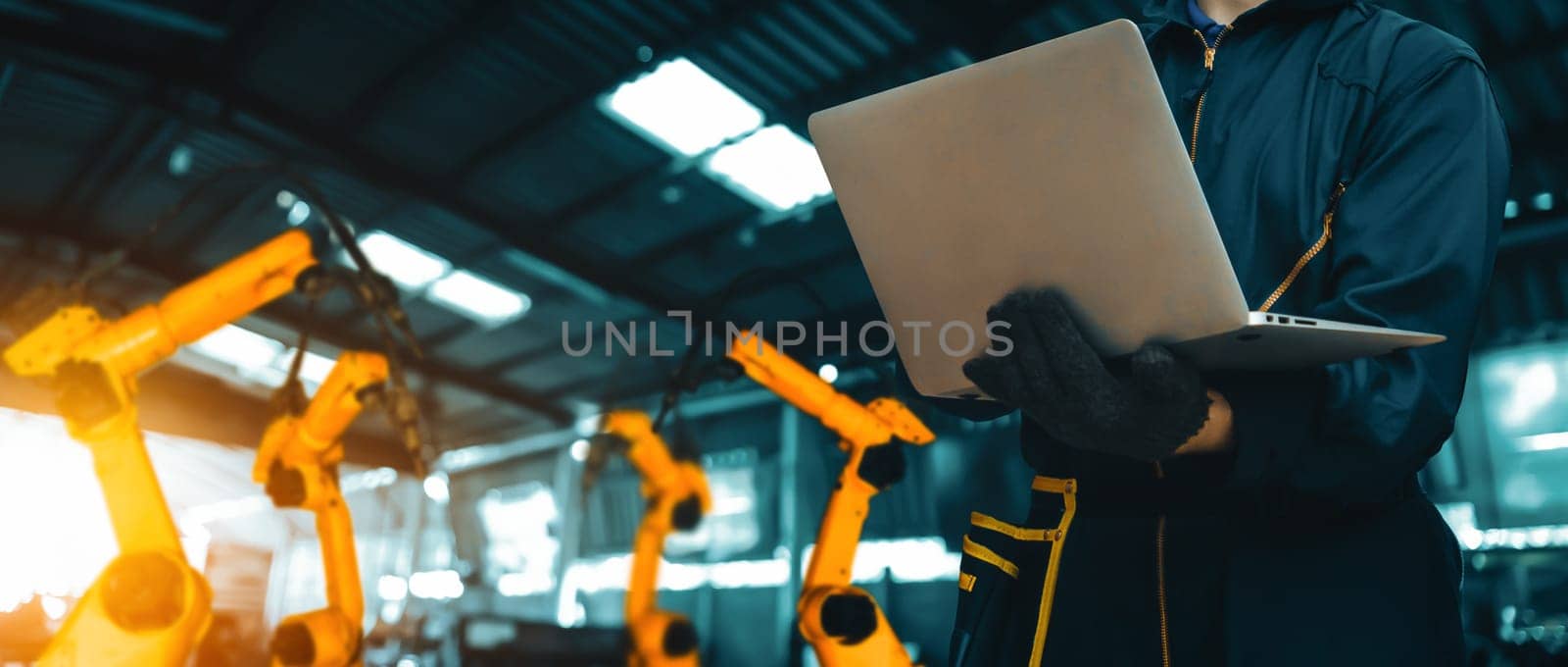MLP Engineer use advanced robotic software to control industry robot arm in factory. Automation manufacturing process controlled by specialist using IOT software connected to internet network.