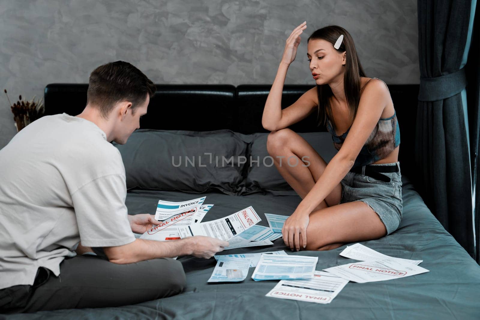Stress young family couple worried about credit card bill. Unveiling by biancoblue