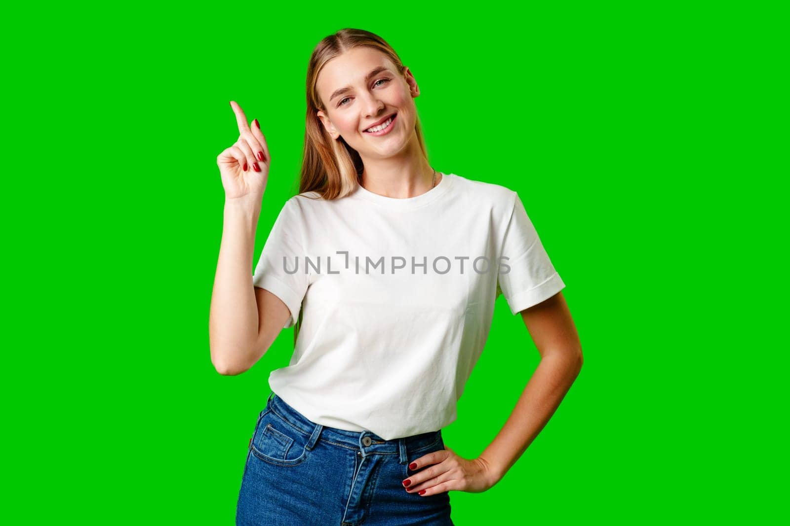 Young Woman Pointing Up Against Green Background by Fabrikasimf