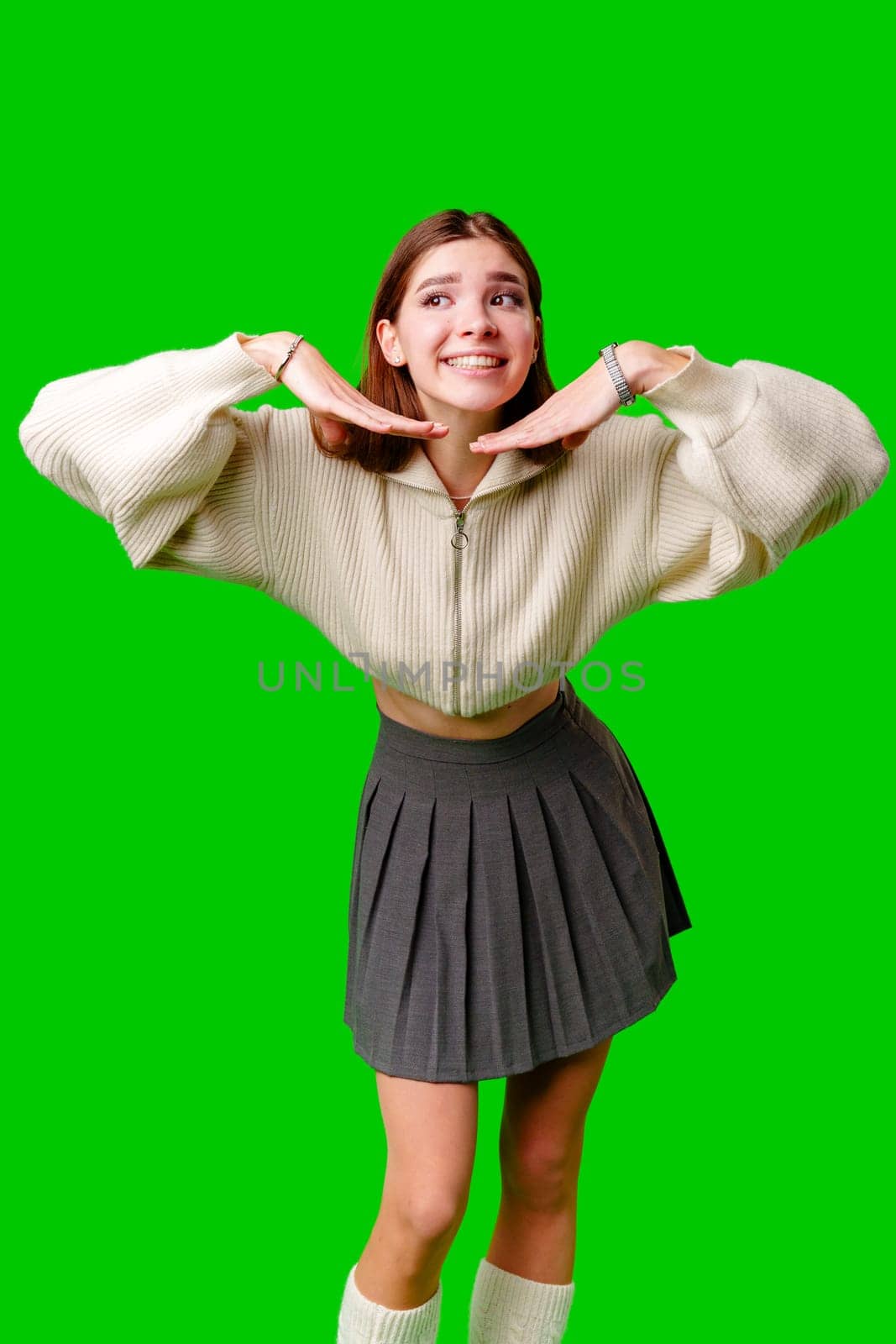 Smiling Young Woman Posing in Casual Clothing Against a Green Background by Fabrikasimf