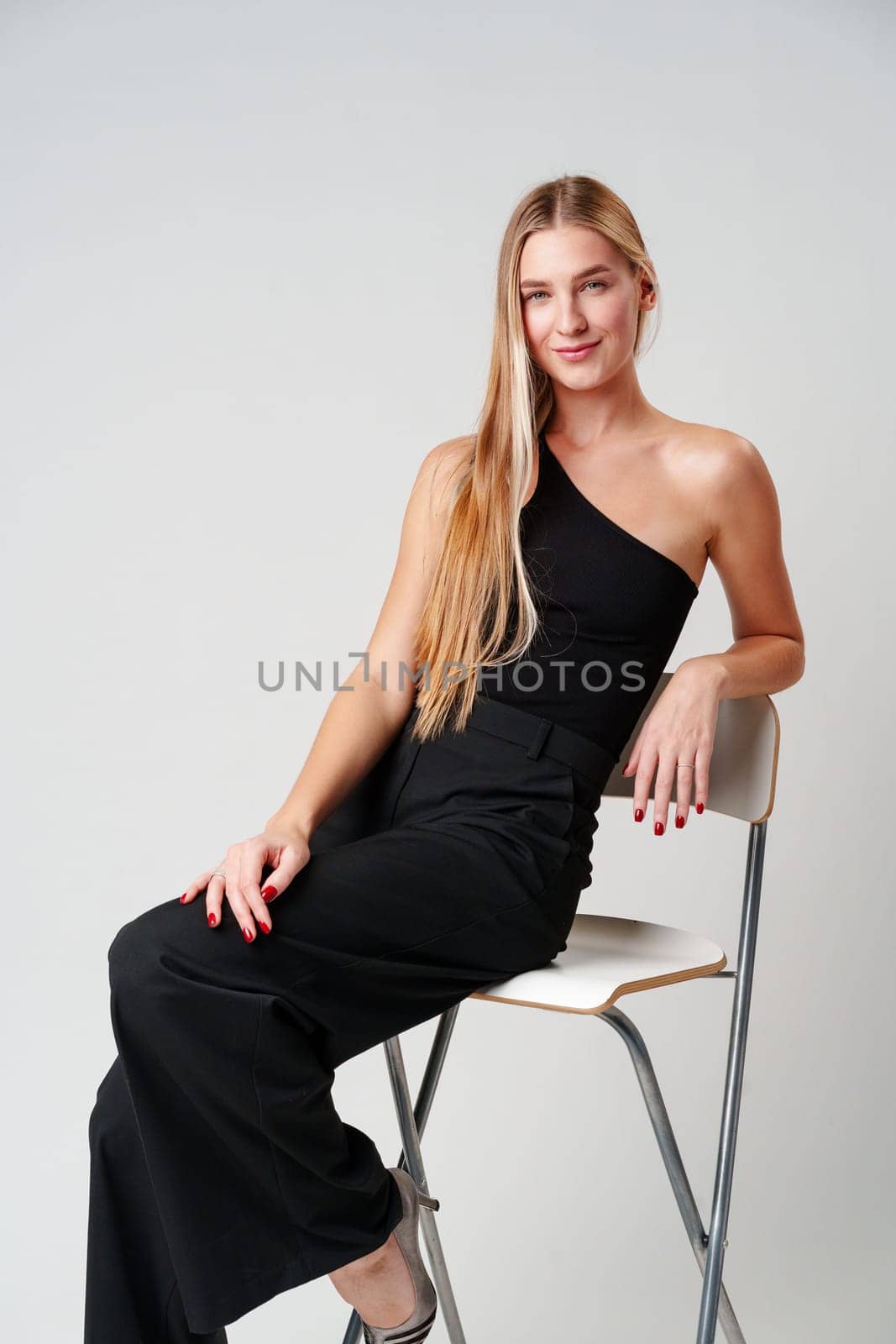 Young Woman Sitting on Chair Posing for Picture in studio