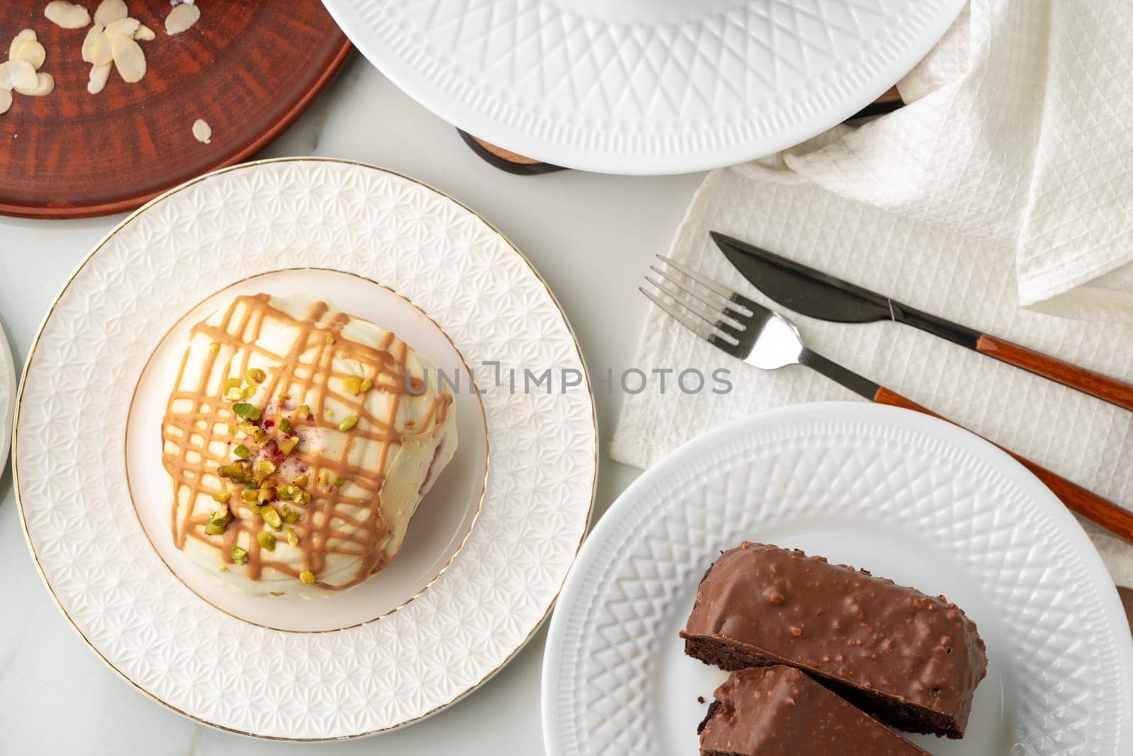 Homemade desserts sponge cake and cinnamon bun on table by Fabrikasimf