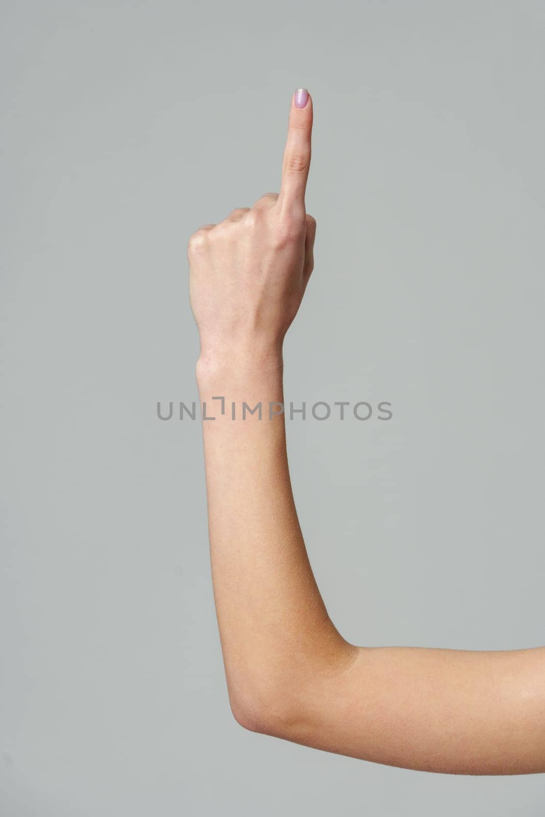 Female hand gesturing numbers on gray background by Fabrikasimf
