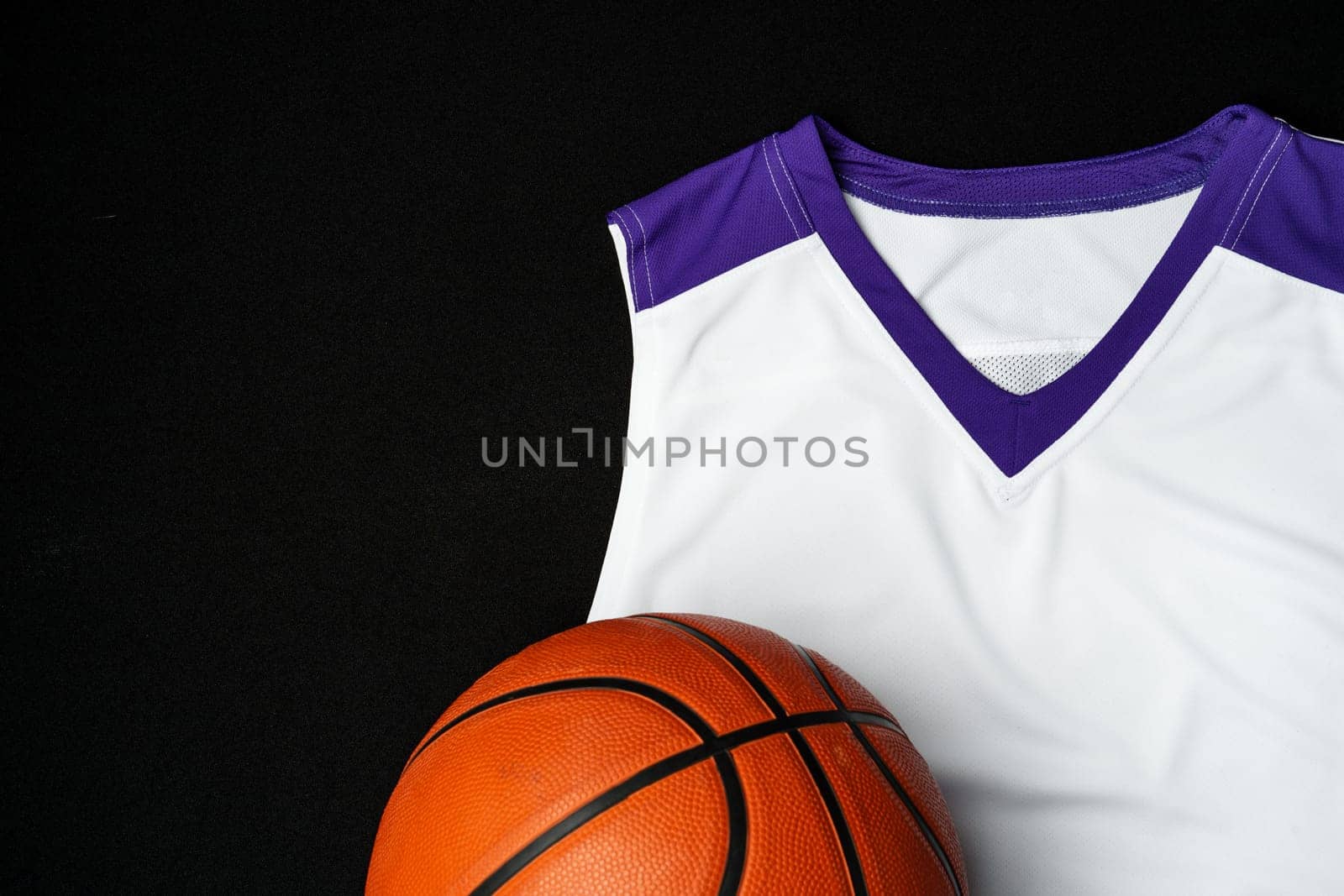 Close-Up of Basketball and White and Purple Jersey on a Black Background by Fabrikasimf