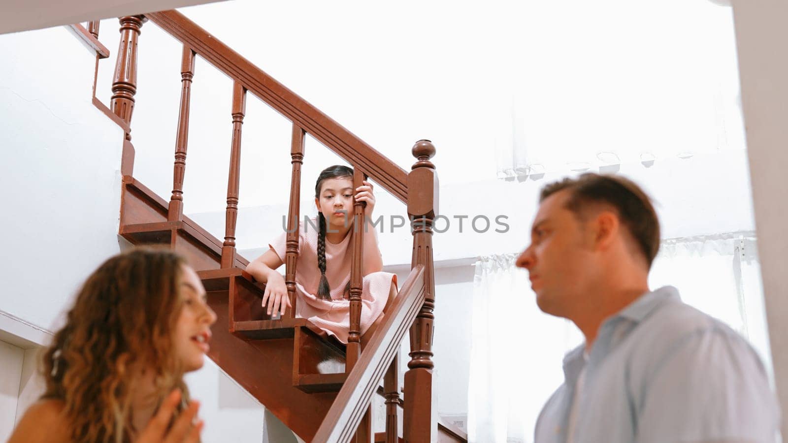 Unhappy young girl watch her parent arguing from the stair. Synchronos by biancoblue