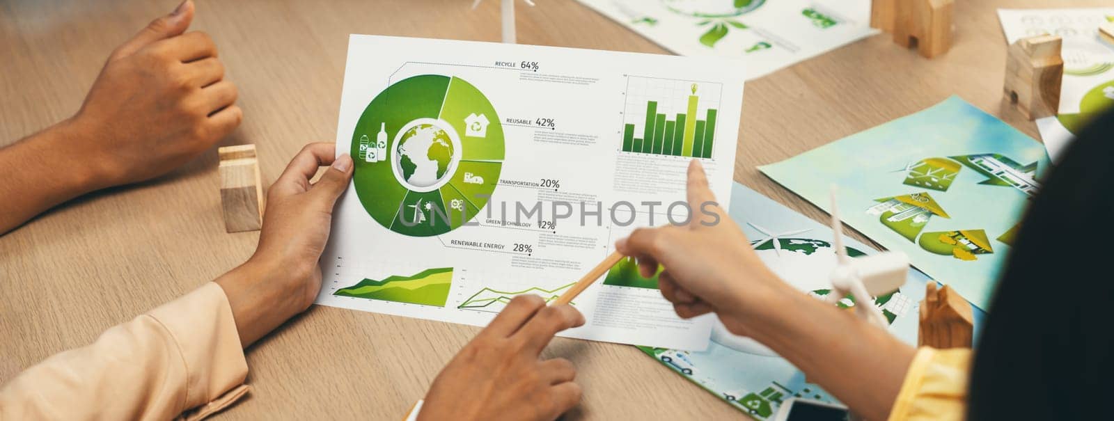 Professional businessman interested in invested in green businesses when he see rising graph on table with environmental document and wooden block scatter around. Closeup. Focus on hand. Delineation.