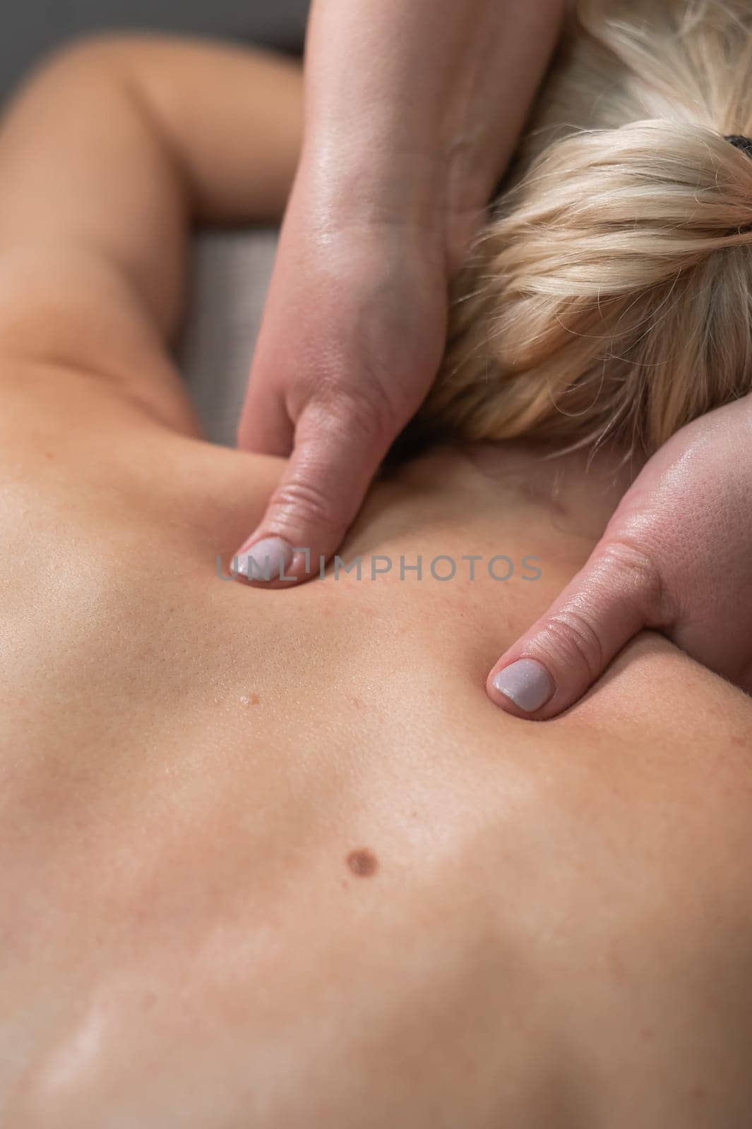 A woman undergoing a massage of the cervical-collar area. by mrwed54