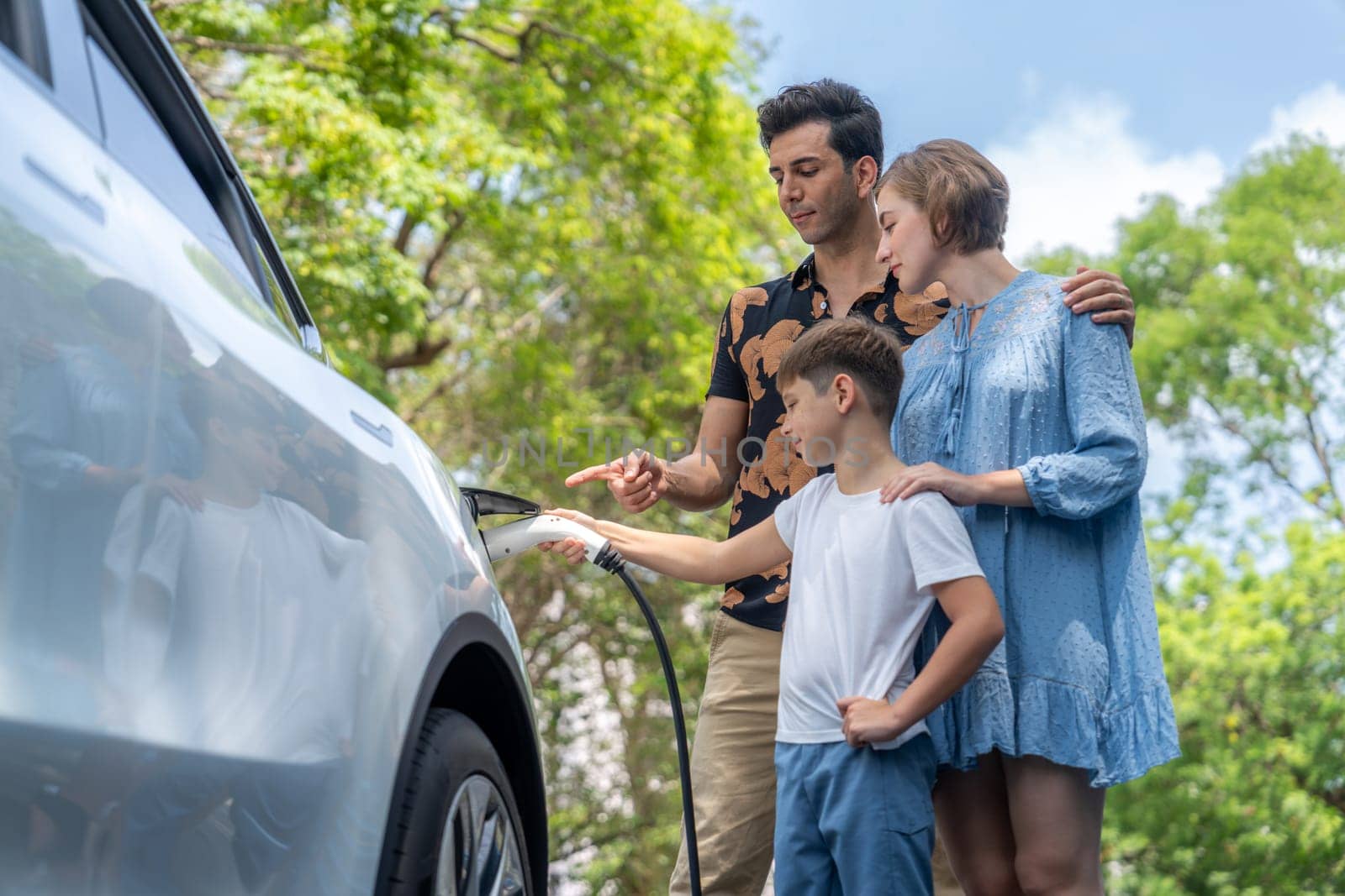 Family road trip vacation with electric vehicle, lovely family recharge EV car with green and clean energy. Natural and eco friendly car travel for sustainable environment. Perpetual
