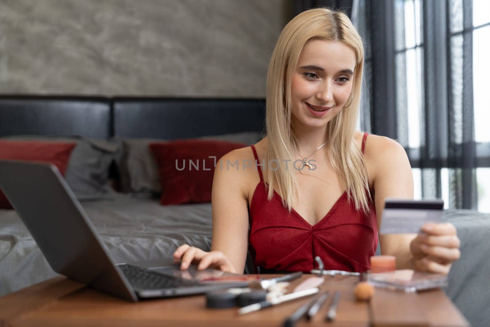 Young woman using laptop with credit card for internet banking, online shopping E commerce by online payment gateway at home office. Modern and convenience online purchasing with debit card. Blithe