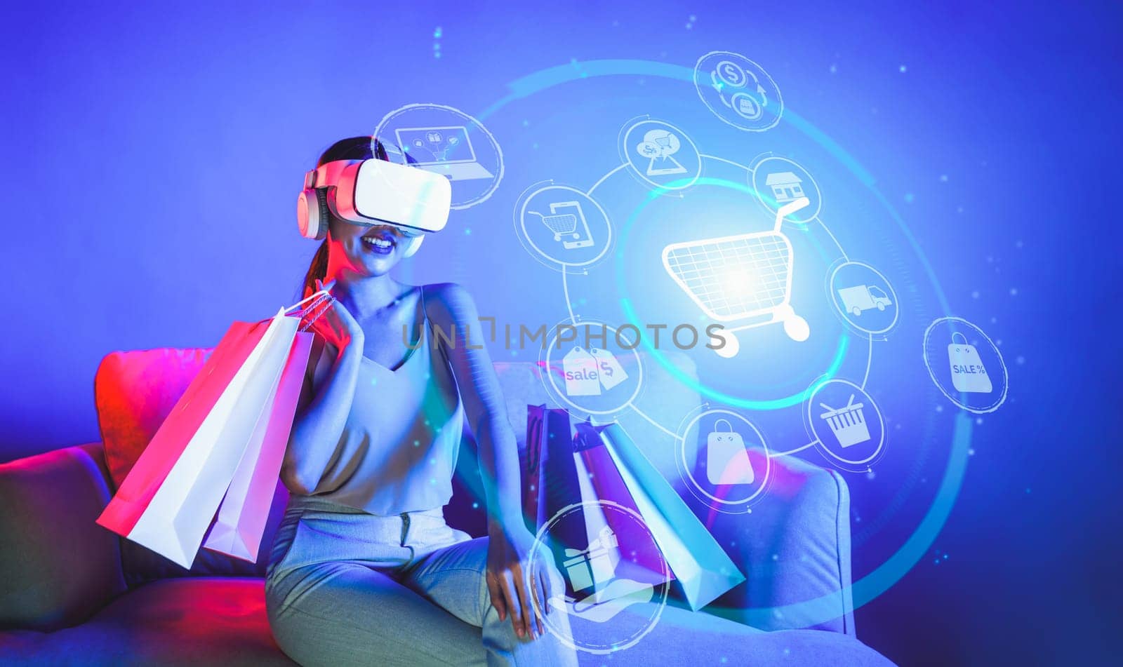 Smart female sitting on sofa while wearing VR headset connecting metaverse, future cyberspace community technology. Elegant woman enjoy open interface online store menu shop product. Hallucination.