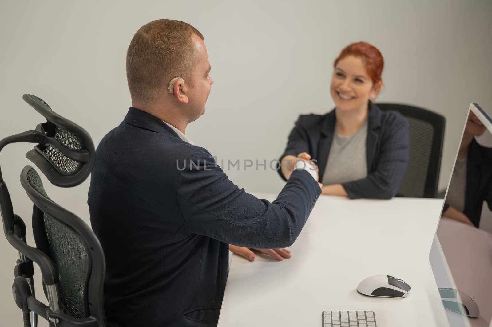 Business partners shake hands while concluding a deal. Deaf business man
