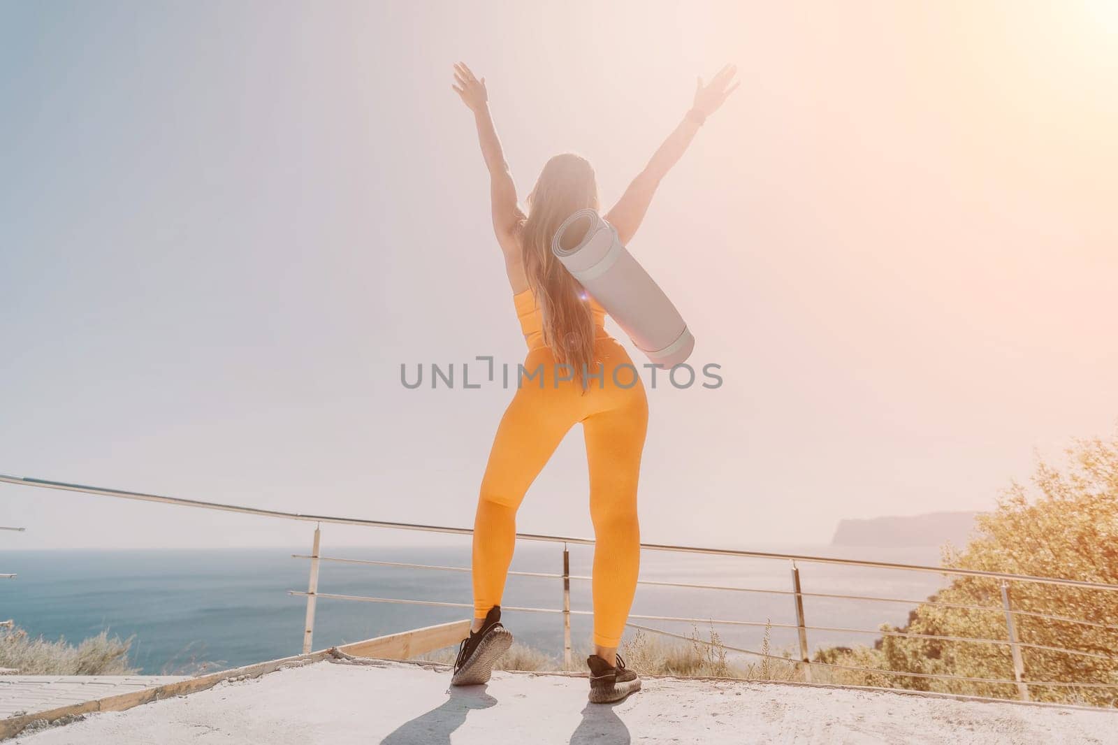 Fitness woman sea. Outdoor workout on yoga mat in park near to ocean beach. Female fitness pilates yoga routine concept. Healthy lifestyle. Happy fit woman exercising with rubber band in park.