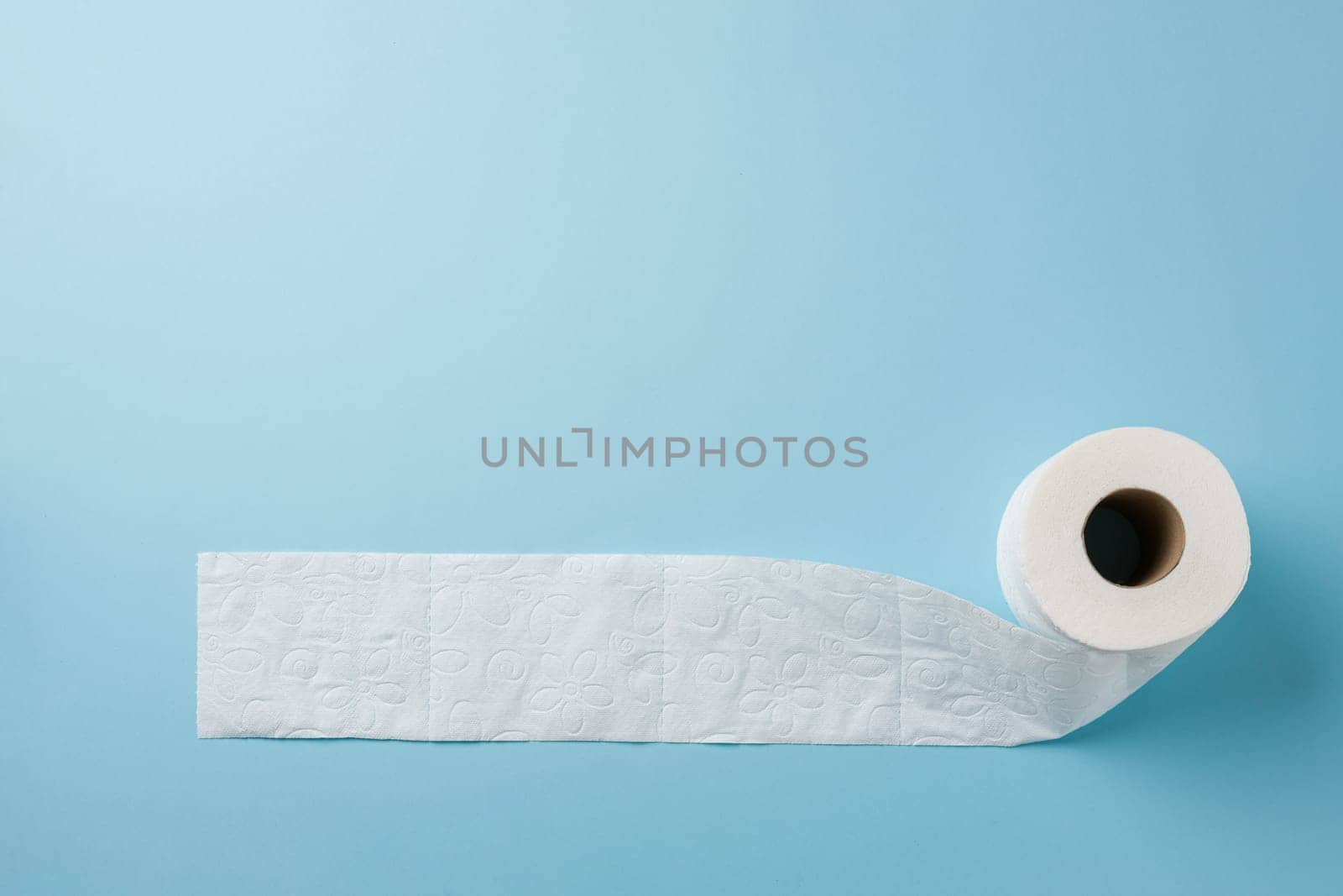 Top view of toilet paper roll on blue background by Sonat