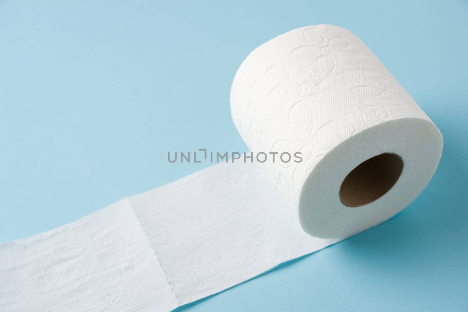 Top view of toilet paper roll on blue background by Sonat