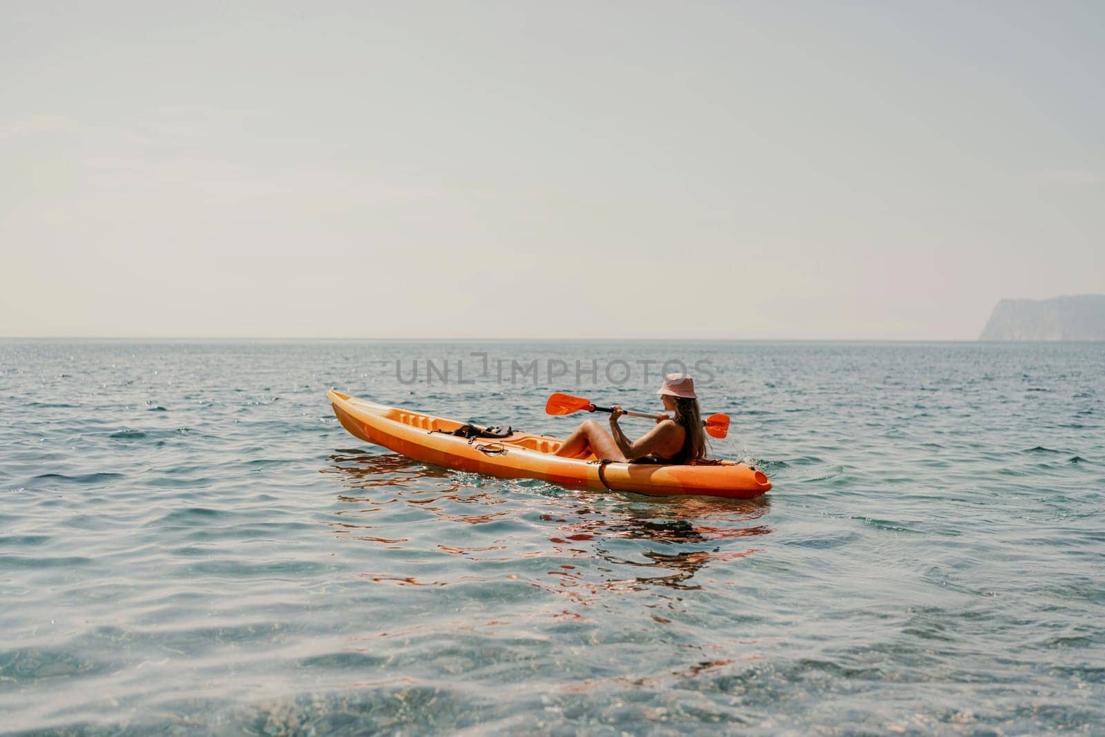 Kayak sea woman. Happy attractive woman with long hair in red swimsuit, swimming on kayak. Summer holiday vacation and travel concept