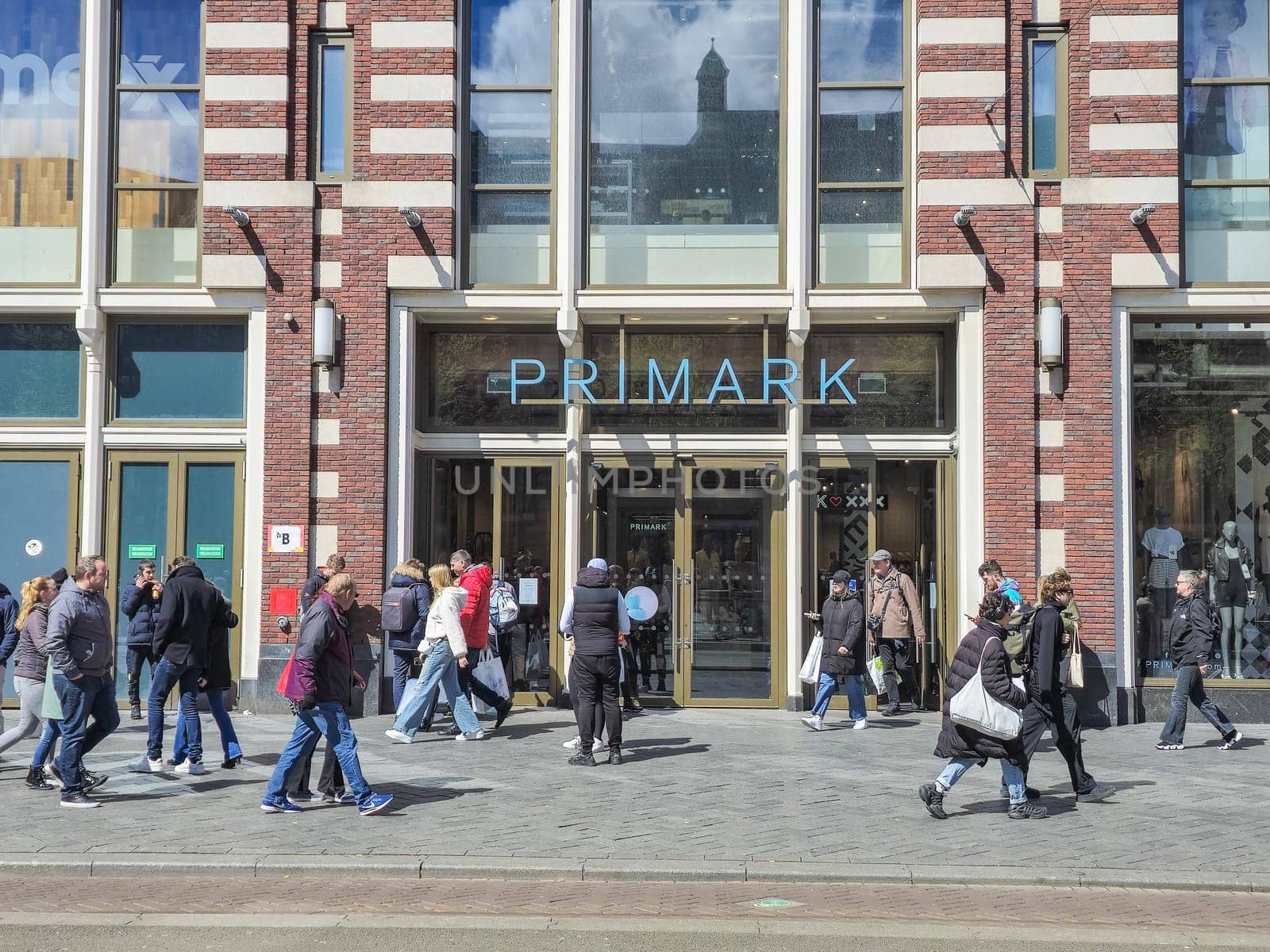 A diverse group of individuals leisurely walk past a Primark shop, each lost in their own thoughts, absorbing the grandeur and history of their surroundings by fokkebok