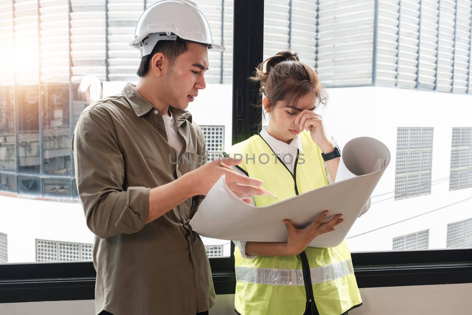 The chief engineer has a stress discussion with the engineering team about the construction project plan and work plan. by wichayada