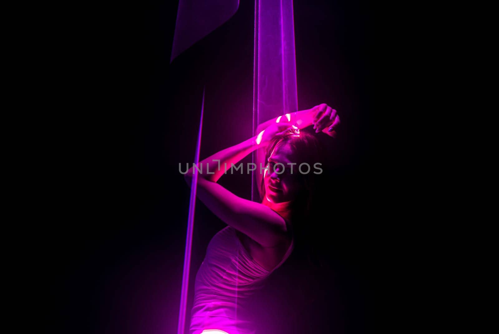 Beautiful woman dancing under pink illumination, laser light, neon party night club. Projection mapping. Interactive exposition installation. High quality photo