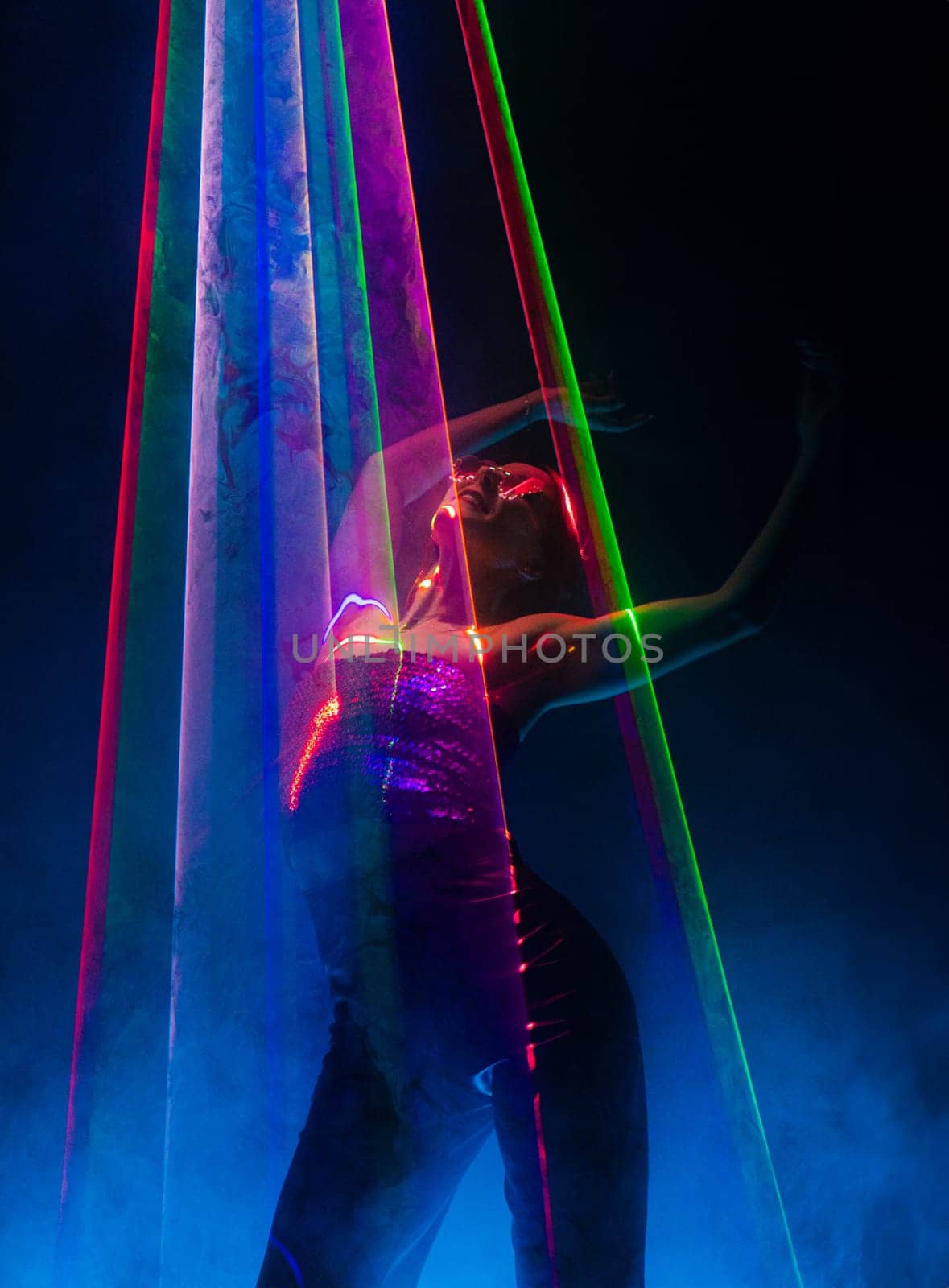 Beautiful woman dancing under colorful illumination, laser light, neon party night club. Performance, projection mapping. Interactive exposition installation, Optical and visuals concept. High quality