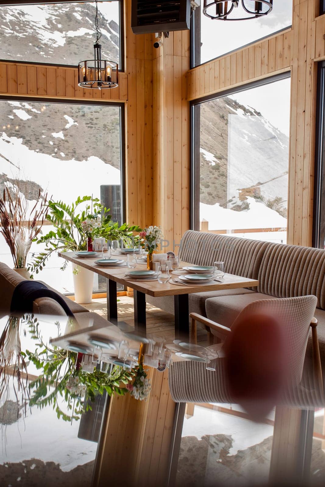 Elegant restaurant interior with snowy mountain view and warm ambiance. by Pukhovskiy