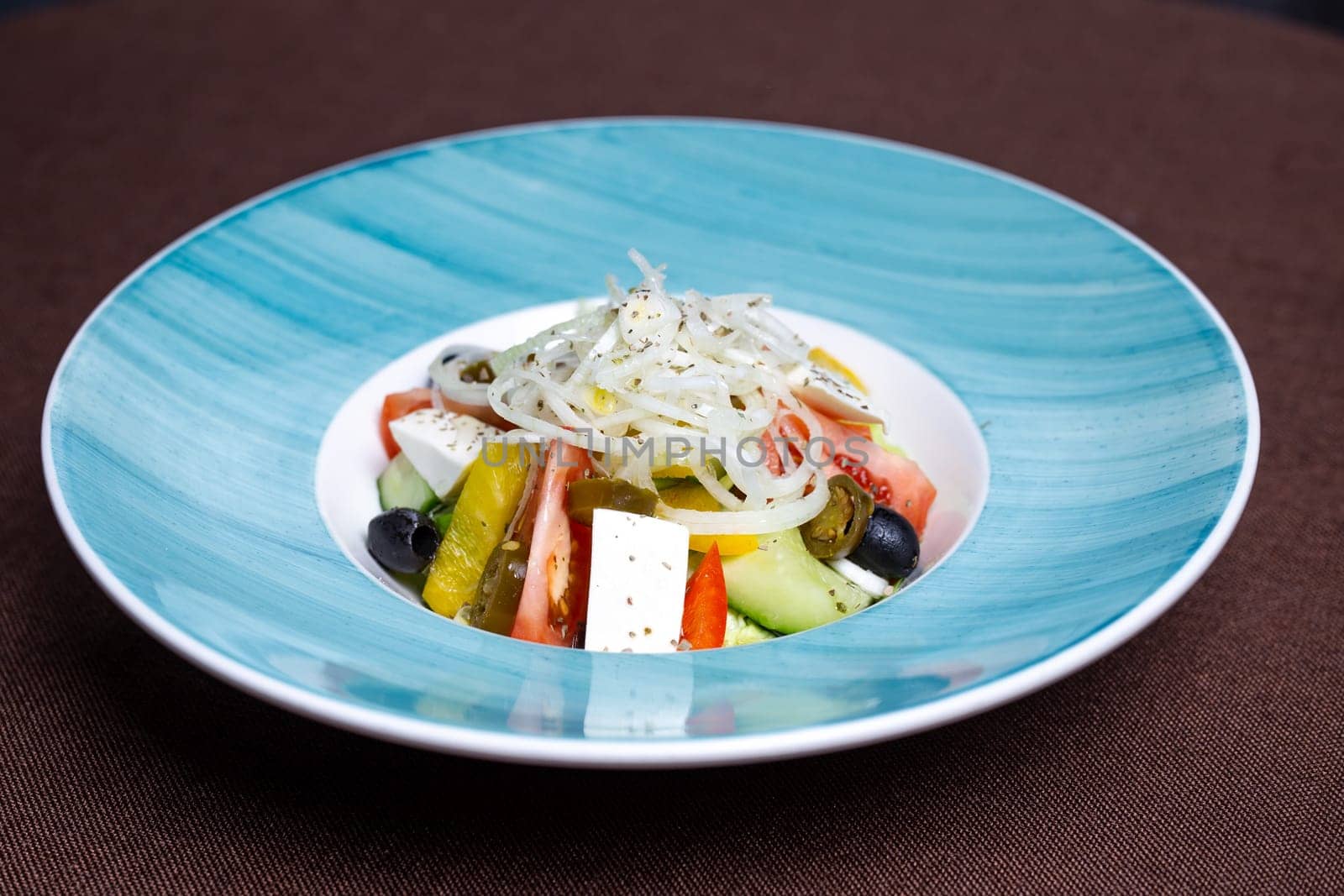 Healthy Greek salad with fresh tomatoes, cucumbers, olives, feta cheese, vinaigrette. Delicious and light