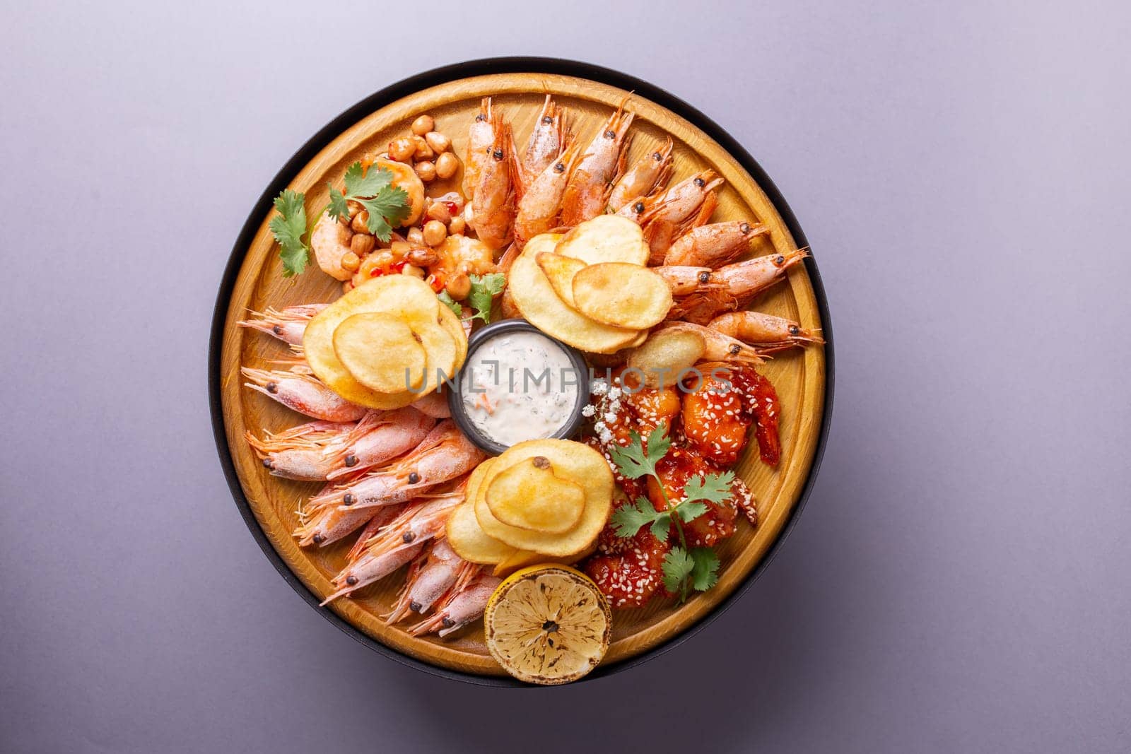 Fresh seafood platter with shrimps, lemon, and potato chips. by Pukhovskiy
