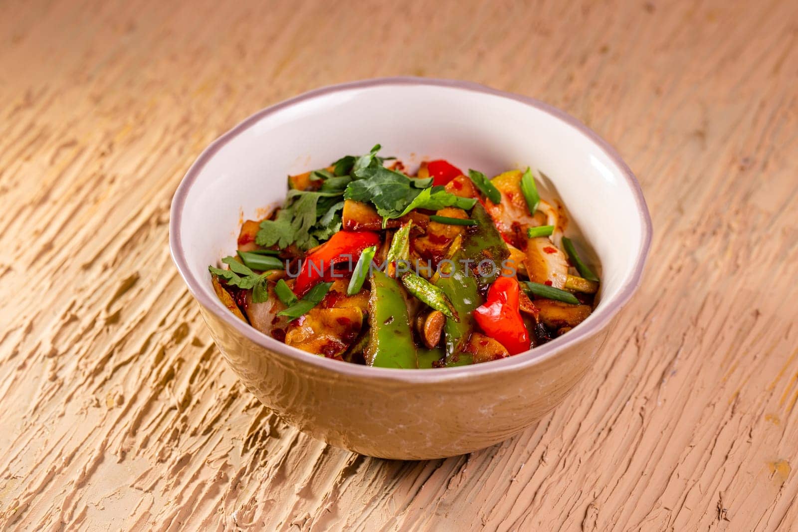 Healthy, colorful dish with snap peas, green beans, and red bell pepper in a rustic bowl. Served on a wooden table.