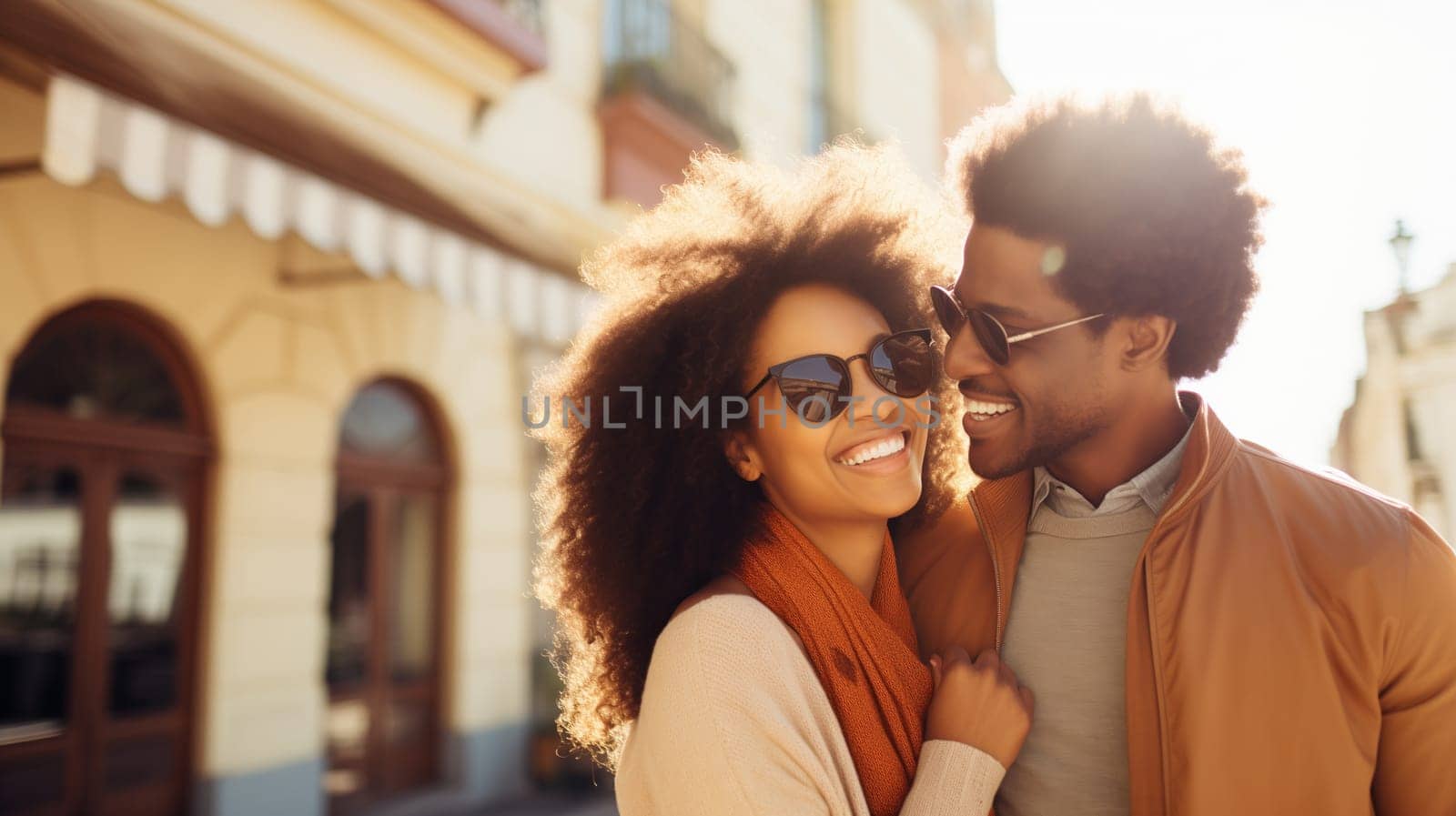 Lifestyle portrait of happy smiling young black couple enjoys a summer walk in sunny city