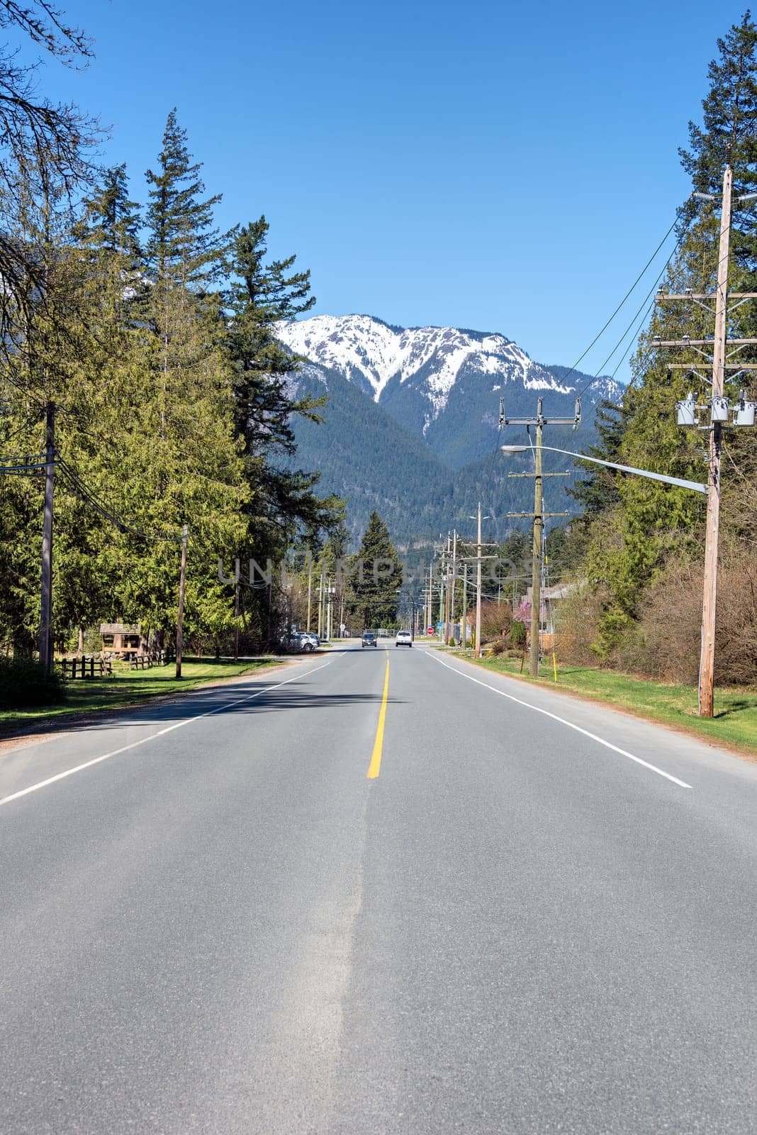 Street in small town in Canada with bluesky and snow top mountain as the background