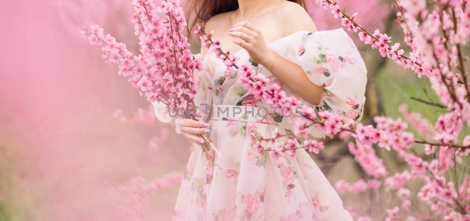 A girl is walking through a field of pink peach flowers. She is wearing a white dress and carrying a basket. The scene is peaceful and serene, with the pink flowers creating a beautiful by Matiunina