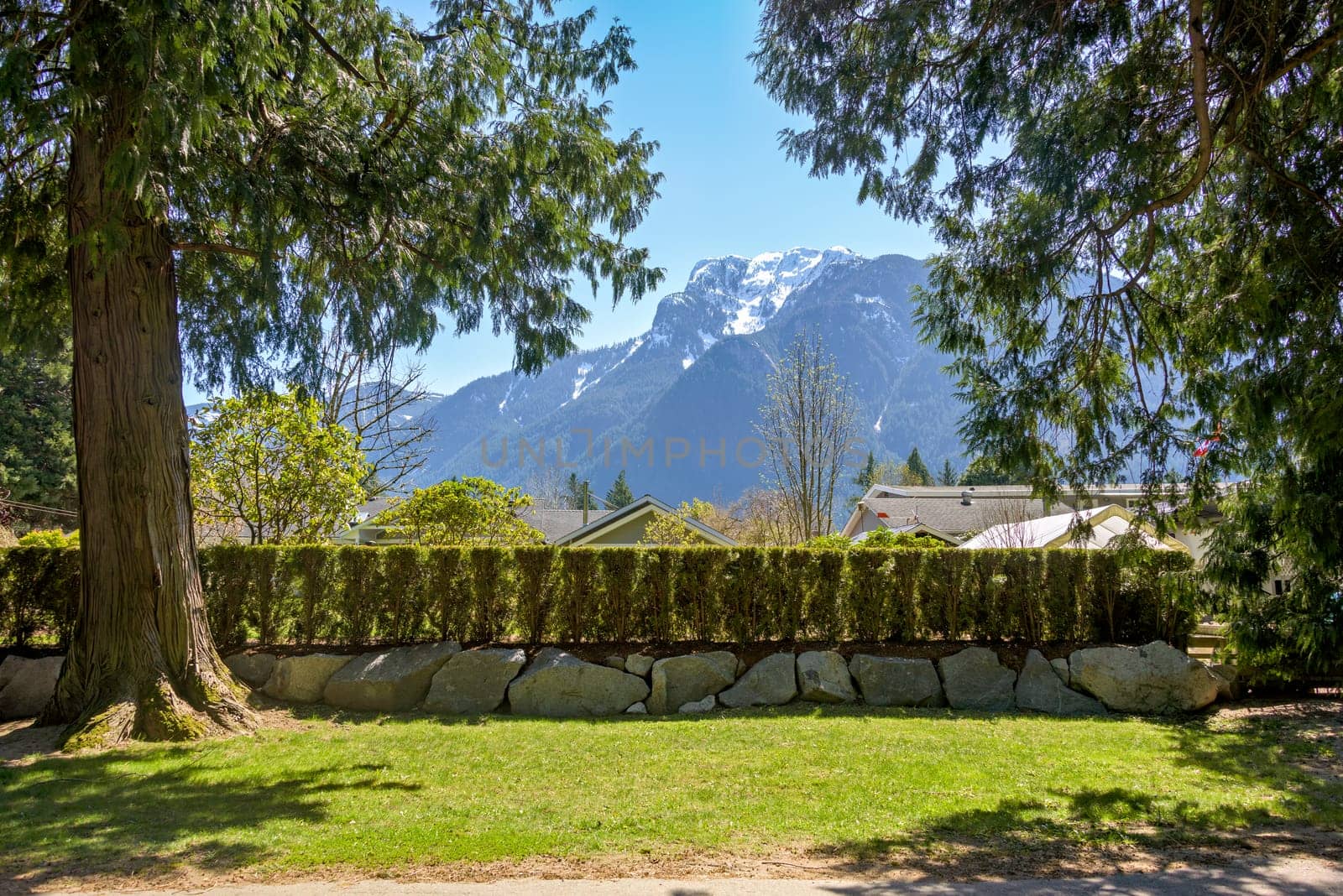 Residential area of a small town in Canada with snow top mountain view by Imagenet