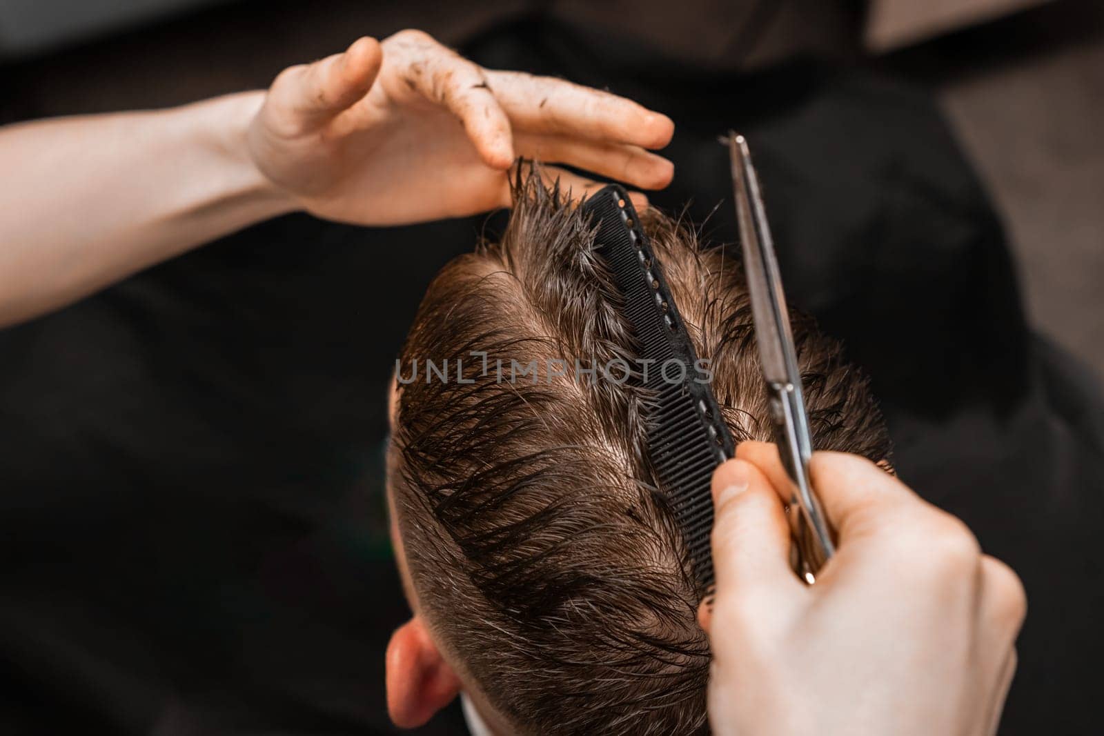 Stylist cuts man hair using comb and scissors in barbershop by vladimka