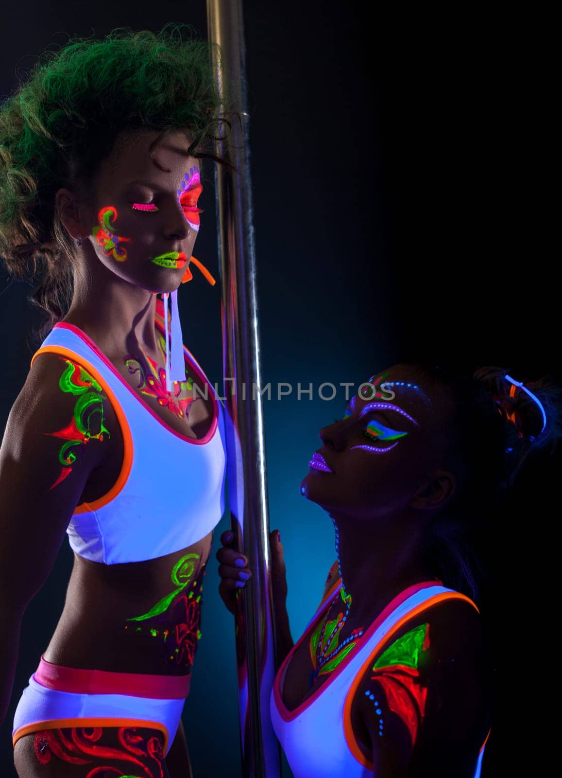 Studio portrait of dancers with bright glowing bodyart