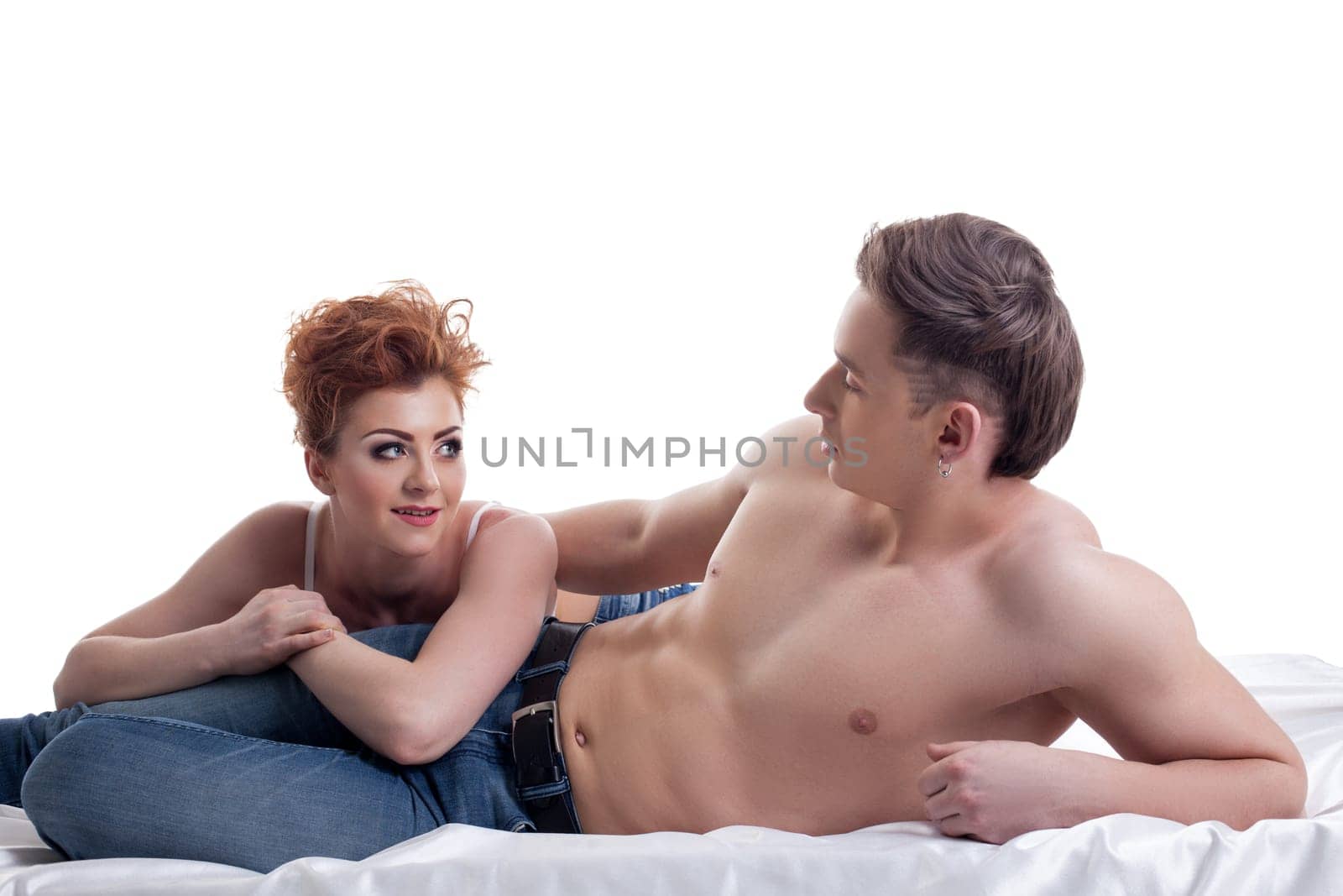 Red-haired girl and her sexy boyfriend posing in bed