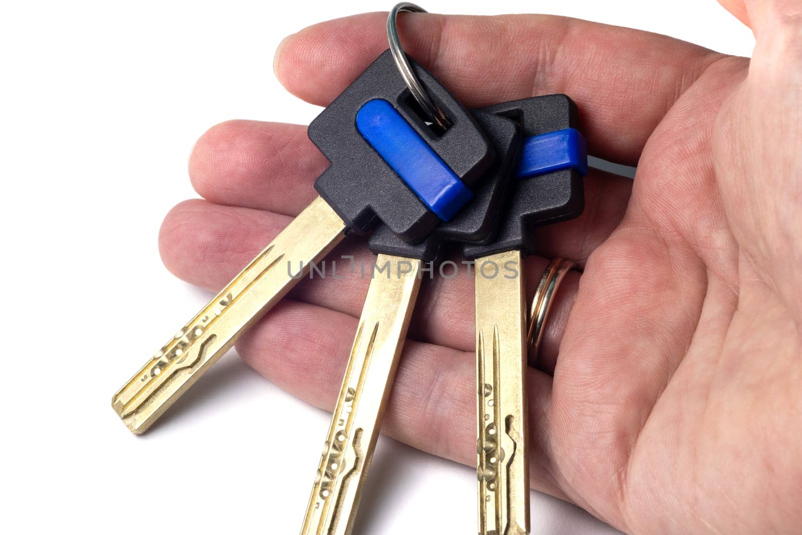 Bunch of modern door keys on the hand palm isolated on a white background. Keys with black plastic head and space for logo or name, close-up view