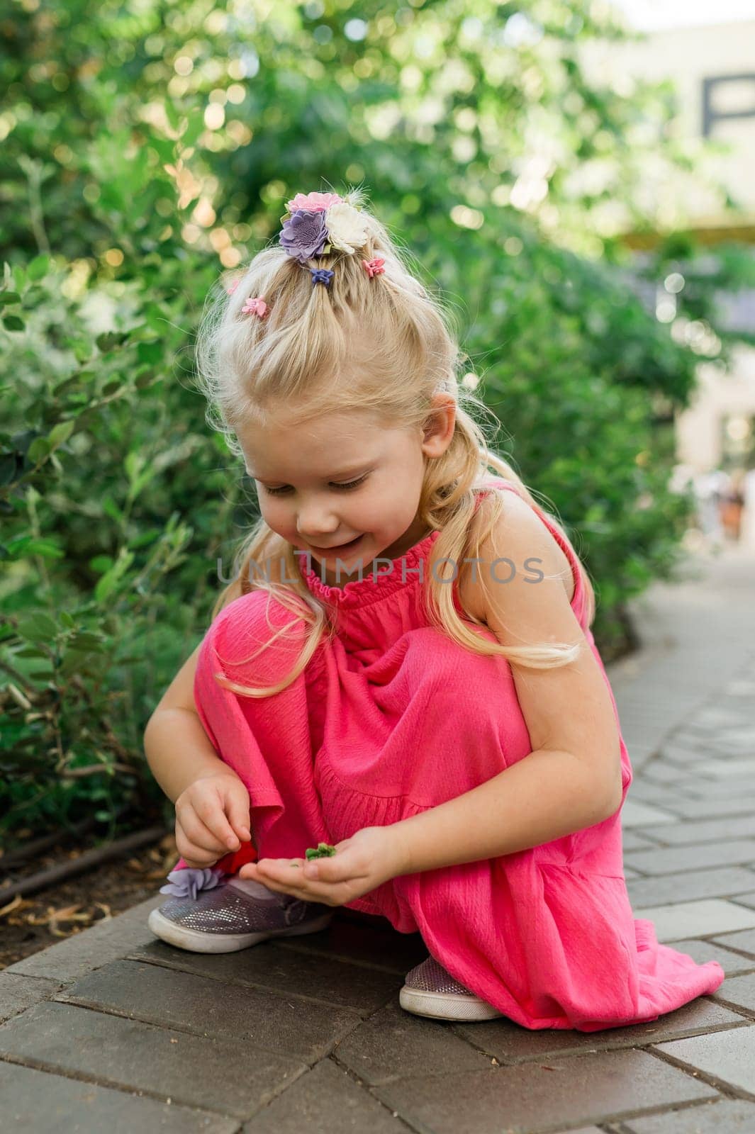 Child girl walks and have fun outdoor with cochlear implant on the head. Hearing aid and treatment concept. Copy space vertical.