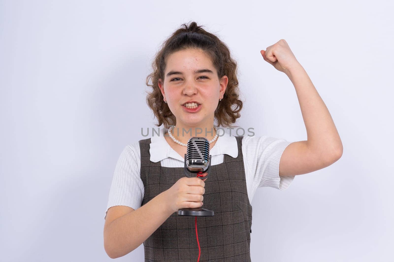 With microphone in hand positive teenage girl singer, young karaoke singer hold microphone. by Zelenin