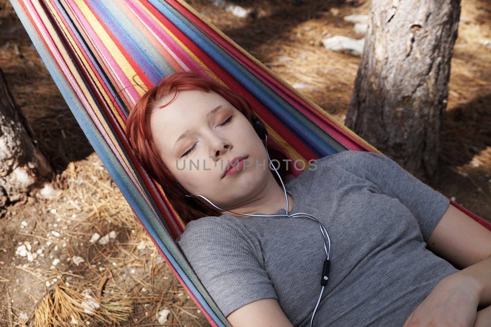 teenage girl sleeping in a hammock outdoors by Annado