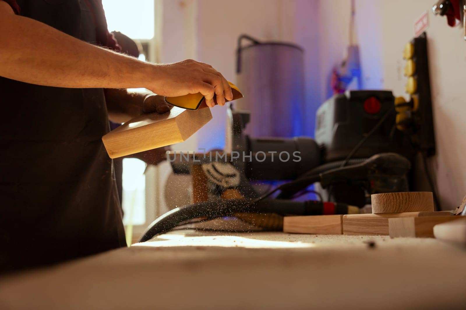 Artisan in studio using sandpaper for smoothing wooden surface, creating wood art designs, enjoying diy hobby. Man using sanding sheets to refurbish damages suffered by timber block, close up shot