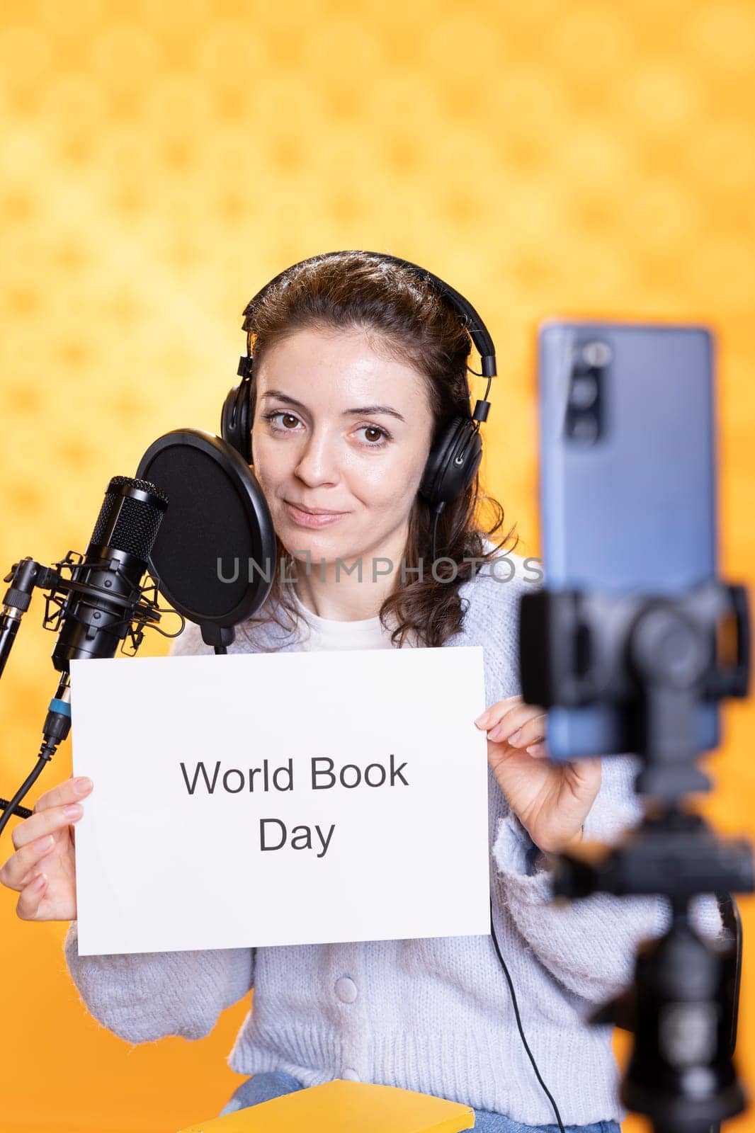 Content creator promoting reading during world book day, studio background by DCStudio